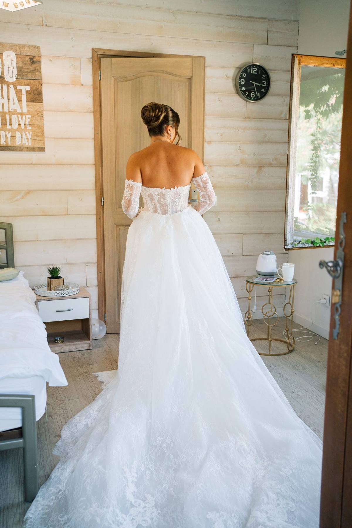 Dos de la robe de mariée devant une porte en bois