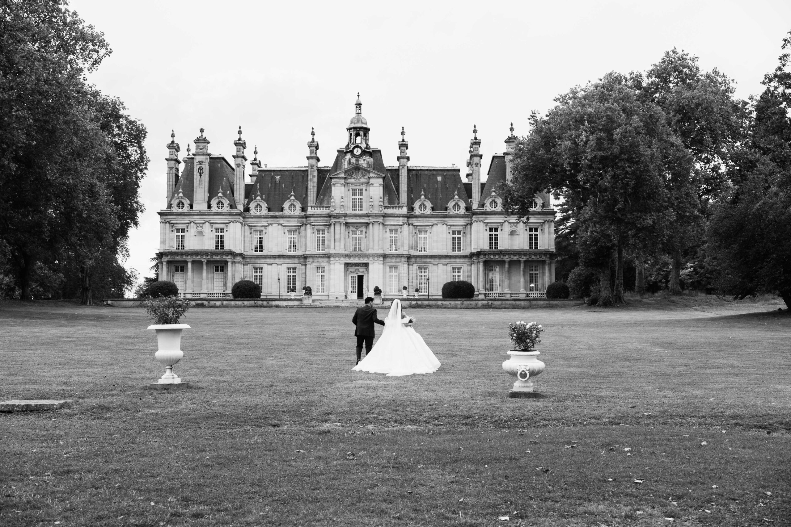 Mariés devant un château, en noir et blanc